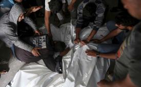 Warga Palestina berduka atas jenazah kerabatnya yang tewas dalam serangan udara Israel, di kamar mayat di Rafah.