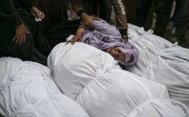 Warga Palestina menangis di dekat jenazah keluarga mereka yang tewas dalam serangan udara Israel.