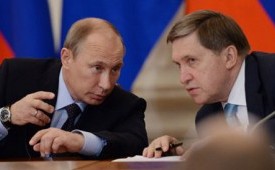 Yuri Ushakov (kanan) berbincang dengan Presiden Vladimir Putin