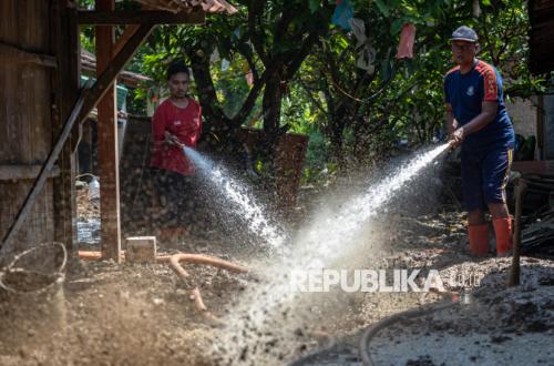 Petugas Gabungan Gotong Royong Bantu Warga Bersihkan Material Banjir di Demak