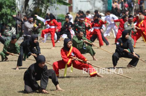 Sejumlah anggota perguruan silat melakukan latihan bersama di Kelurahan Pojok, Kota Kediri, Jawa Timur, Kamis (10/8/2023). Latihan bersama 13 perguruan silat pada kegiatan penutupan TNI Manunggal Membangun Desa (TMMD) ke-117 tersebut sebagai ajang silaturahmi antarperguruan silat guna mencegah tawuran. 