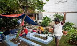 In Picture: Rumahnya Terendam Banjir, Warga Pejaten Timur Mengungsi di Kuburan