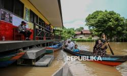 In Picture: Sungai Kahayan Meluap, Warga Gunakan Perahu Motor untuk Menuju TPS