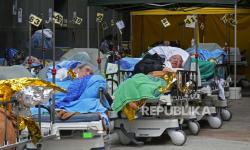  Pasien berbaring di ranjang rumah sakit saat mereka menunggu di ruang tunggu sementara di luar Caritas Medical Center di Hong Kong Rabu, 16 Februari 2022. Ada bukti nyata bahwa rumah sakit Hong Kong menjadi kewalahan oleh lonjakan Covid terbaru, dengan pasien di tandu dan di tenda-tenda yang terlihat oleh petugas medis pada hari Rabu di luar rumah sakit Caritas.