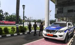 Pegawai Kejagung melintas disamping mobil Polisi Militer yang terparkir di Gedung Kejaksaan Agung, Jakarta, Senin (27/5/2024)