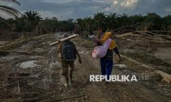 Siti Bayah (44) bersama saudaranya Nurlela (40) berjalan menyusuri jalan pedesaan antara Desa Babo dan Desa Rantau Bintang saat akan pulang ke Desa Jor, Aceh Tamiang, Aceh (21/12/2025). Siti dan Nurlela menempuh perjalanan sepanjang 40 kilometer dengan berjalan kaki untuk mencari kabar keluarganya  pascabanjir bandang di Desa Seumadam.