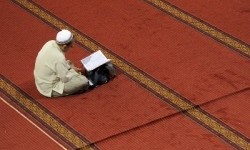 Seorang umat Muslim membaca Alquran usai melaksanakan shalat dhuha (ilustrasi). Niat Sholat Dhuha dan Doanya