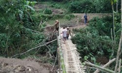 Warga melintas jembatan darurat di Desa Indrajaya, Kecamatan Sukaratu, Kabupaten Tasikmalaya, Senin (2/3). Jembatan utama yang berada di Desa Santanamekar, Kecamatan Cisayong, rusak terdampak longsor yang terjadi pada Jumat (28/2).
