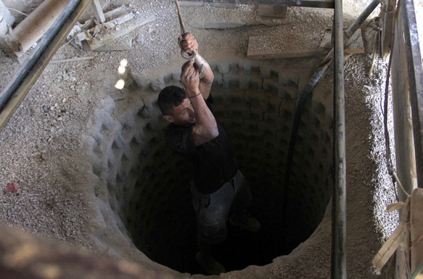 Seorang pekerja Palestina diturunkan dengan tali ke dalam terowongan penyelundupan yang digali di bawah perbatasan Gaza-Mesir di Jalur Gaza selatan pada 27 Agustus 2013. (AFP/File)