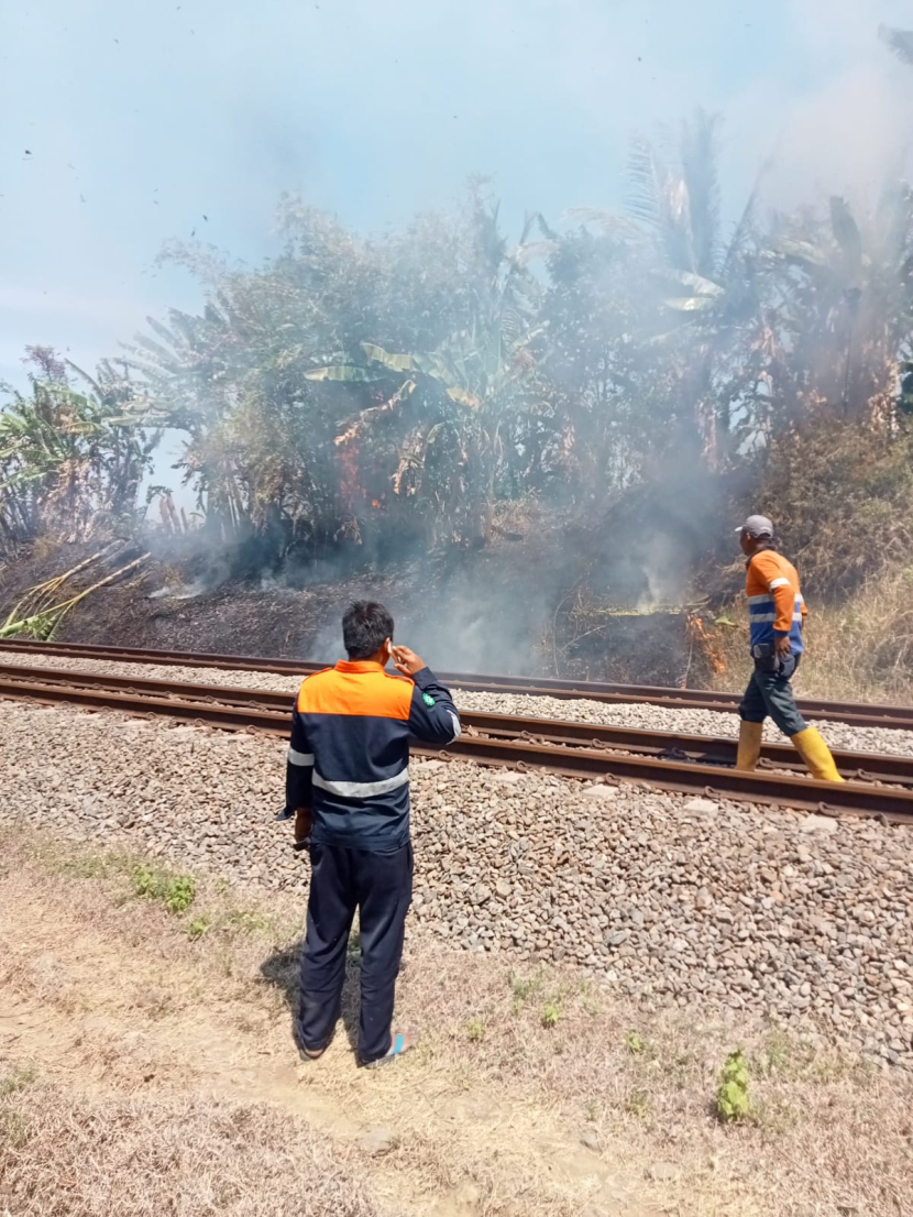 Petugas dari Daop 5 Purwokerto sedang memadamkan kebakaran rumput di pinggir rel kereta api. (Foto: Humas Daop 5 Purwokerto).