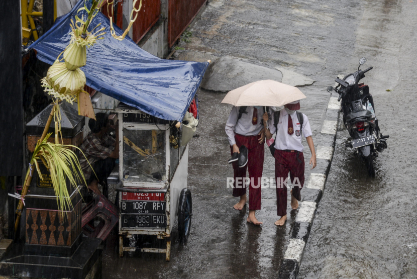 Musim hujan. Bekali anak-anak dengan payung atau jas hujan ketika berangkat ke sekolah. Foto: Republika