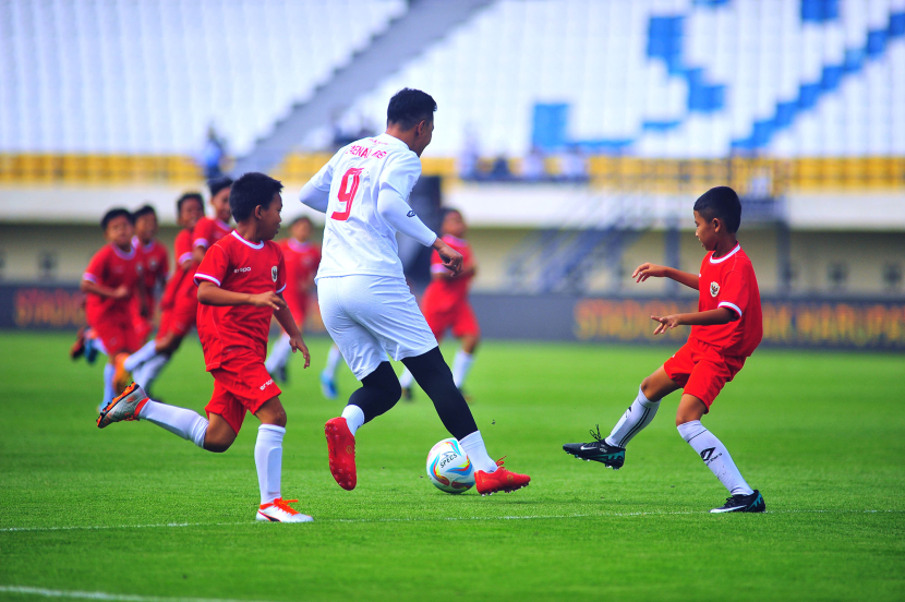 Mantan striker Persib Bandung Zaenal Arief dikerubuti puluhan siswa SSB pada laga funsoccer jelang pembukaan Turnamen Piala Presiden 2024 di Stadion Si Jalak Harupat, Kabupaten Bandung, Jumat (19/7/2024).  (FOTO: YOGI ARDHI/REPUBLIKA NETWORK) Nikon D3, Nikkor 300/2.8 ED MF.