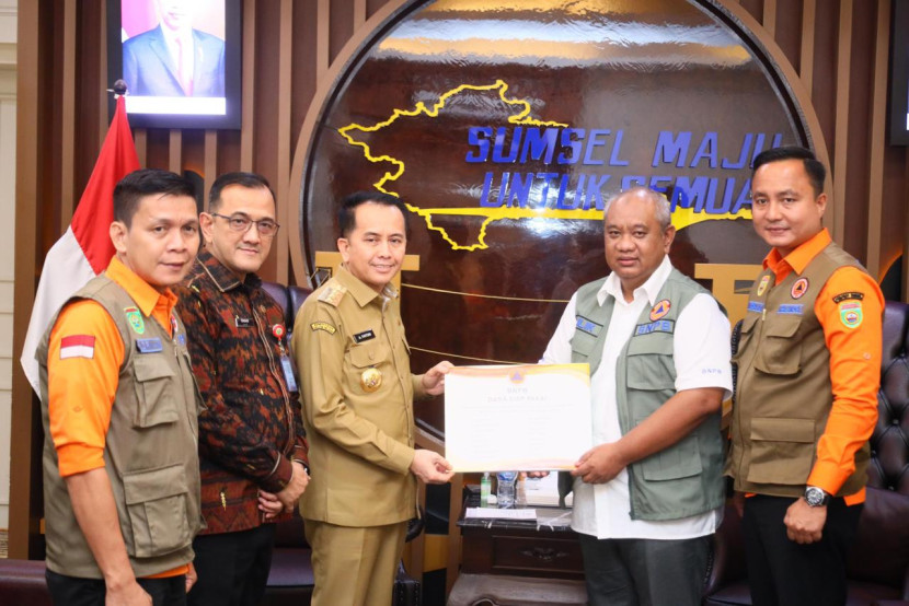 Pj Gubernur Sumsel Agus Fatoni (tiga dari kiri) menerima bantuan dari BNPB yang diserahkan Deputi Bidang Logistik dan Peralatan BNPB Lilik Kurniawa. (FOTO: Humas Pemprov Sumsel) 