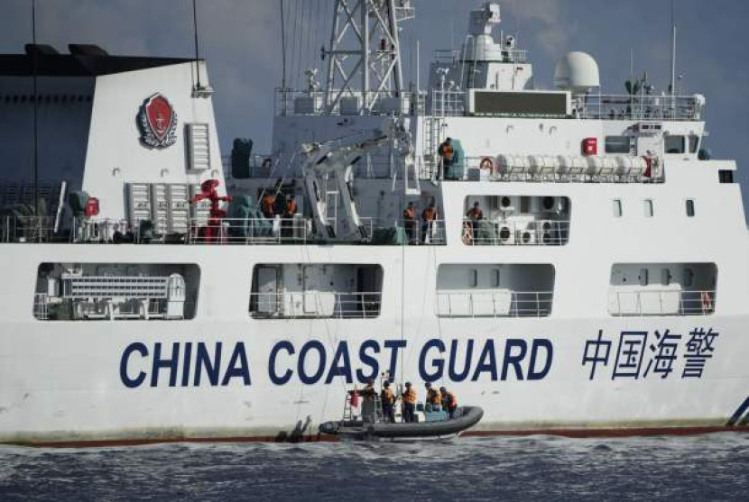 Sebuah kapal Penjaga Pantai Cina menurunkan kru untuk menghadang kapal Penjaga Pantai Filipina BRP Malapascua saat bermanuver memasuki muara Second Thomas Shoal yang dikenal sebagai Ayungin Shoal di Laut Cina Selatan pada Ahad (23/4/2023). (AP Photo/Aaron Favila)