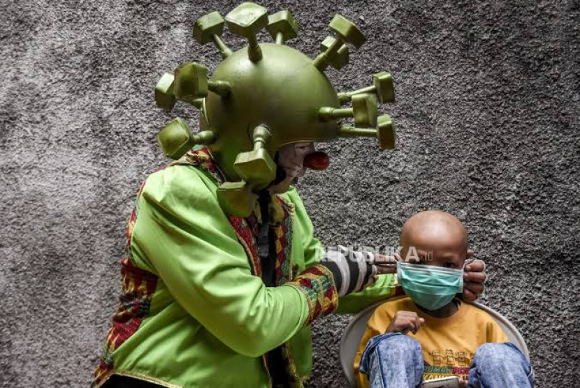 Anggota komunitas Badut Nyetrik Cimahi Bandung Sauyunan (Necis) memasangkan masker ke seorang anak pengidap kanker di Rumah Pejuang Kanker Ambu, Jalan Bijaksana Dalam, Sukajadi, Kota Bandung. Gambar: Republika