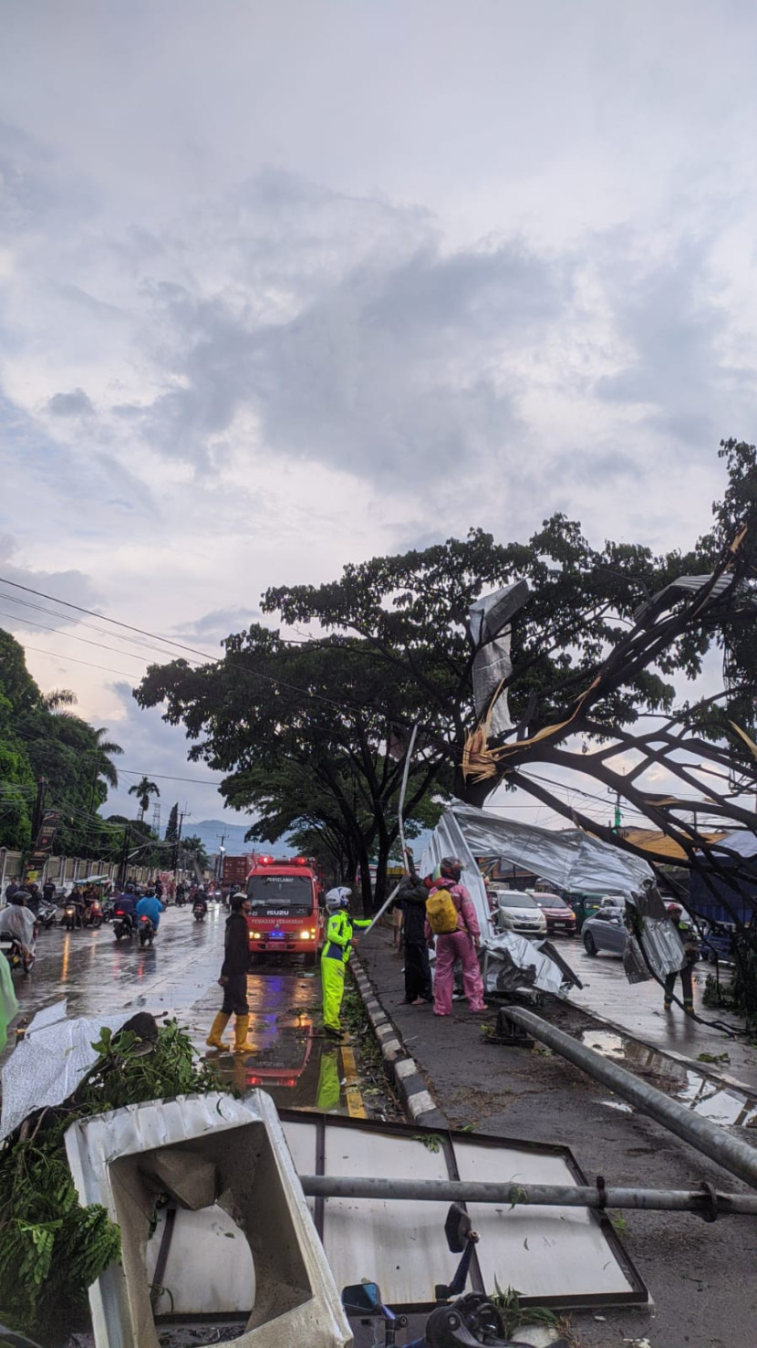 Petugas gabungan melakukan evakuasi material pohon tumbang dan material bangunan yang terbawa angin puting beliung di Jalan Raya Bandung Garut, Rancaekek, Rabu (21/2/2024). Dok Republika. 