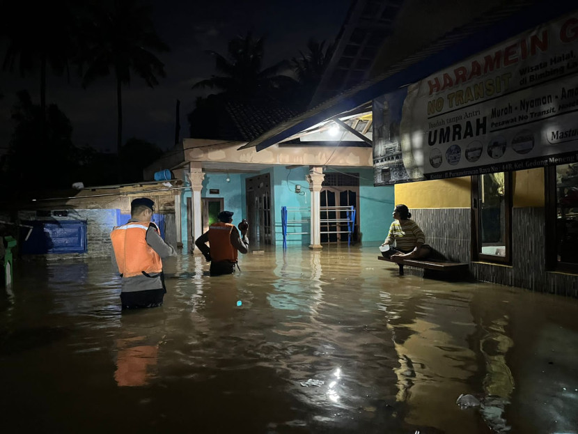 Anggot Brimob Polda Lampung bantu warga korban banjir di Bandar Lampung, Sabtu (24/2/2024) malam. (Foto: Polda Lampung)