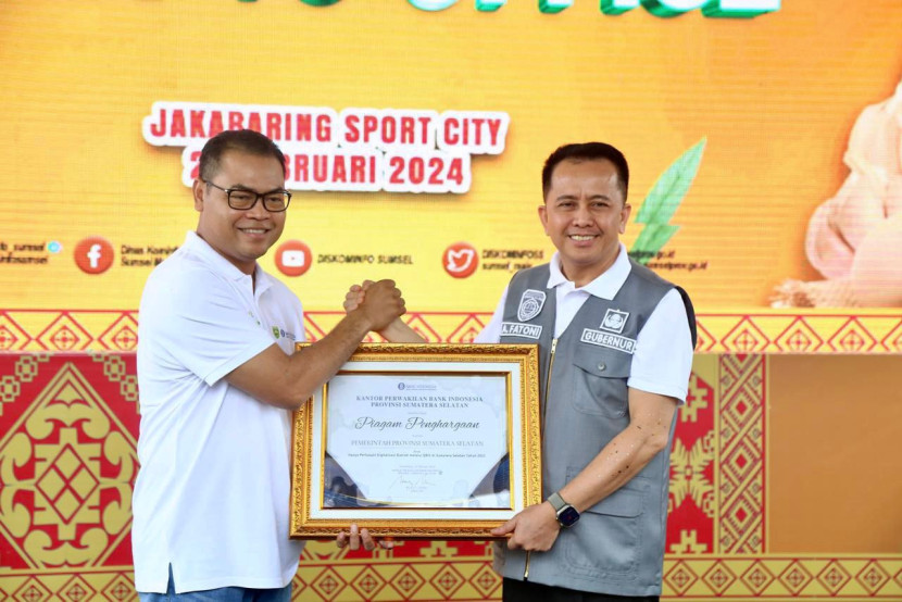 Kepala Kantor Perwakilan BI Sumsel memberikan piagam penghargaan kepada Pemprov Sumsel yang diterima Pj Gubernur Agus Fatoni atas perluasan digitalisasi daerah melalui Qris di Provinsi Sumsel tahun 2023. (FOTO: Humas Pemprov Sumsel)