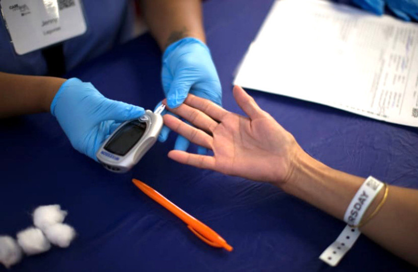 Seseorang menerima tes diabetes di klinik medis gratis Care Harbor LA di Los Angeles, California/Mario Anzuoni-REUTERS