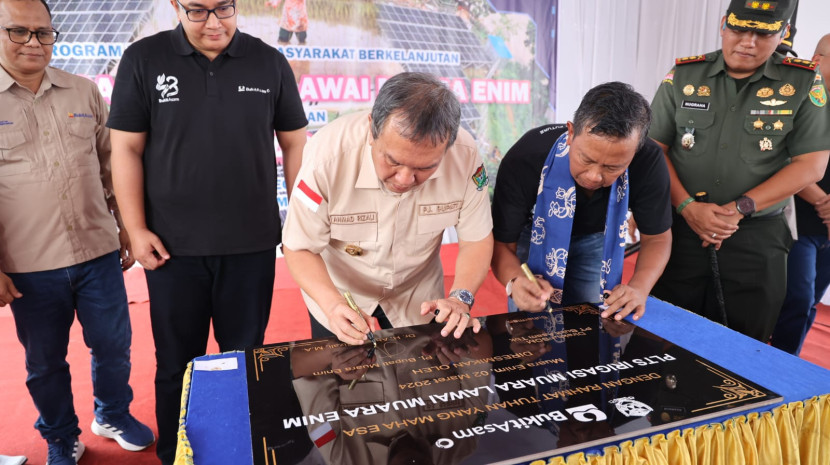 Pj Bupati Muara Enim Ahmad Rizal dan Direktur SDM PTBA menandatangani prasasti peresmian PLTS irigasi Muara Lawai. (FOTO: Humas PTBA)
