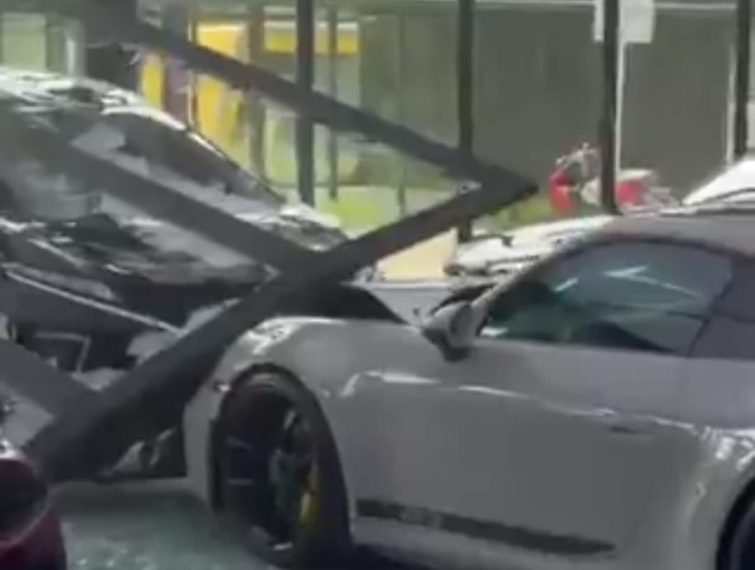 Mobil Daihatsu Xpander menabrak showroom dan merusak Porsche GT3.