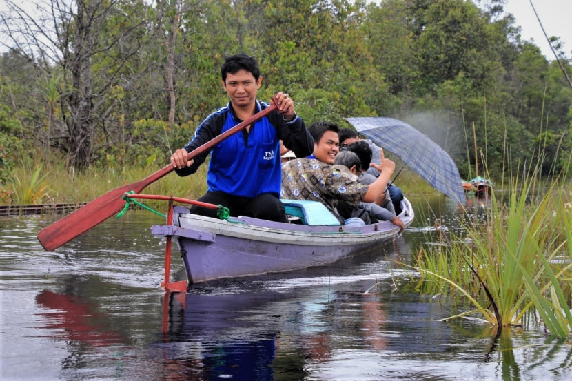 Krisyoyo mendayung perahu klotoknya menyusuri Sungai Sebangau, Palangkaraya, Kalimantan Tengah, beberapa waktu lalu. (Foto: SumatraLink.id/Mursalin Yasland)