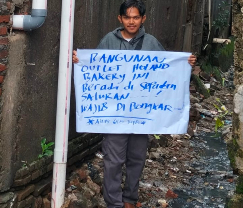 Anggota LSM Kapok sedang melakukan aksi protes dengan adanya dugaan bangunan Holland Bakery yang melanggar garis sepadan saluran air. (Foto: Dok Ruzka Indonesia)