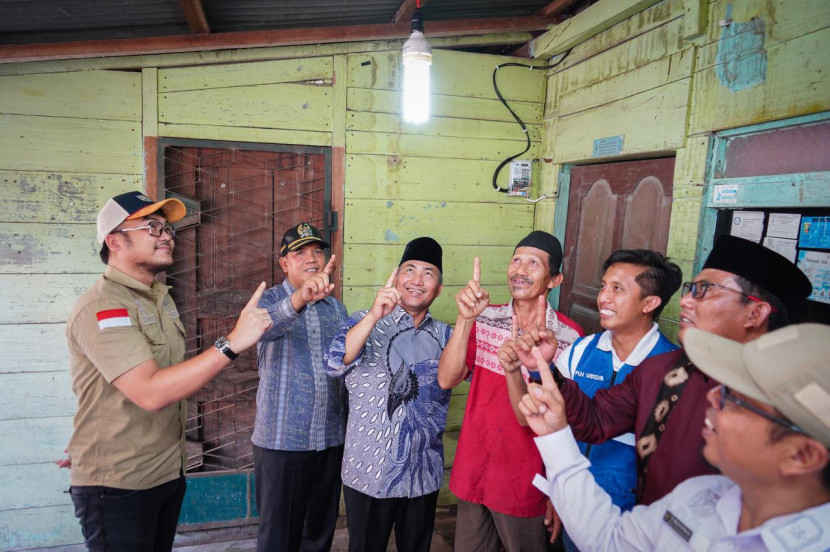 Pj Bupati Apriyadi (ketiga dari kiri) menyambut gembira bersama warga setelah listrik menyala menerangi desa-desa di Muba. (FOTO: Dinkominfo Muba)