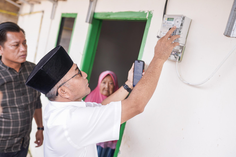 Pj Bupati Apriyadi nenasukan token listrik untuk pelanggan Nenek Suhartini di Sekayu. (FOTO: Dinkominfo Muba)