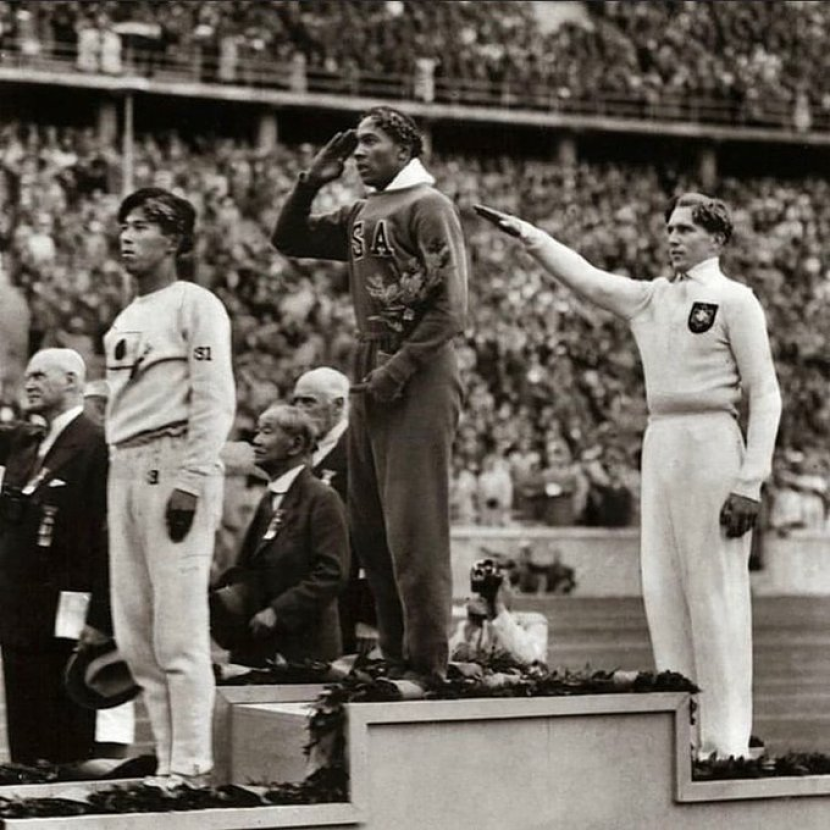 Jesse Owen (tengah) dan Luz di belakangnya yang memberi hormat ala Nazi dengan mengangkat sebelah tangannya.
