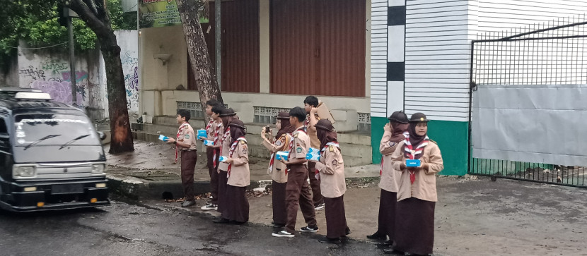 Para anggota Pramuka MAN 1 Kota Sukabumi membagikan takjil dalam gerakam Rantang Pramuka di Jalan RH Didi Sukardi, Senin (25/3/2024).