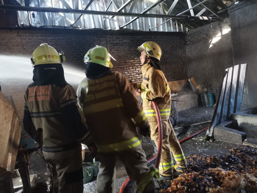 Petugas sedang memadamkan api di pabrik keripik yang terbakar di Kota Bandung