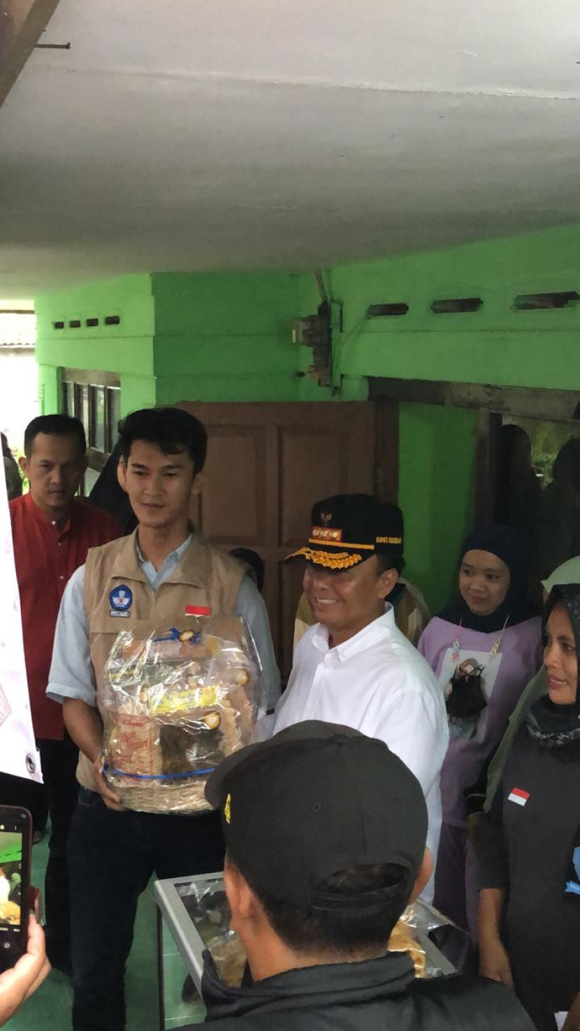 Rizky sedang berfoto dengan aparat desa dan masyarakat Conggeang Wetan, Sumedang  