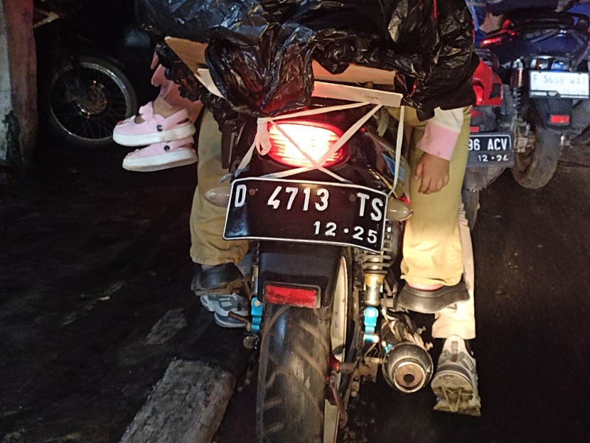 Seorang balita di pangkuan pemudik bersepeda motor bermanuver di antara padatnya kendaraan di Jl Raya Cibiru -Cileunyi - Rancaekek, Bandung, Ahad (7/4/2024). (Foto: Yogi Ardhi/Republika Network)