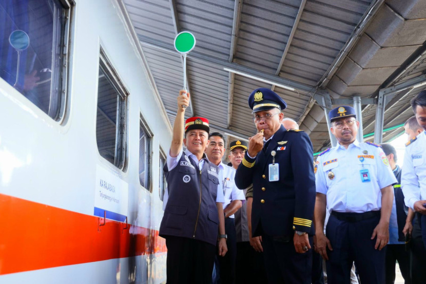 Pj Gubernur Sumsel Agus Fatoni mengenakan topi merah PPKA melepas kereta yang membawa pemudik gratis dari Stasiun Kertapati. (FOTO: Humas Pemprov Sumsel)