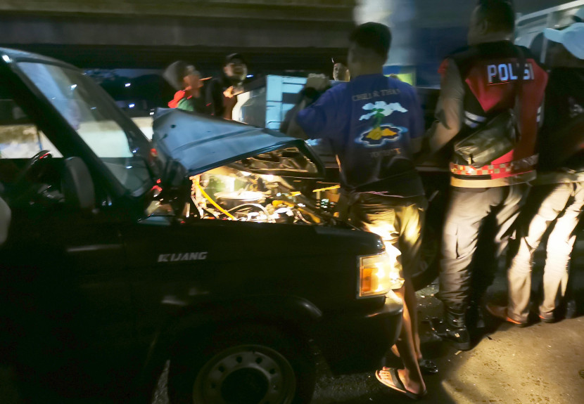 Warga dan petugas polisi mengevakuasi minibus yang terlibat tabrakan beruntun di Ramp jalan tol menuju Gerbang Tol Cileunyi, Jumat (12/4/2024) malam. Foto: Yogi Ardhi/Republika Network