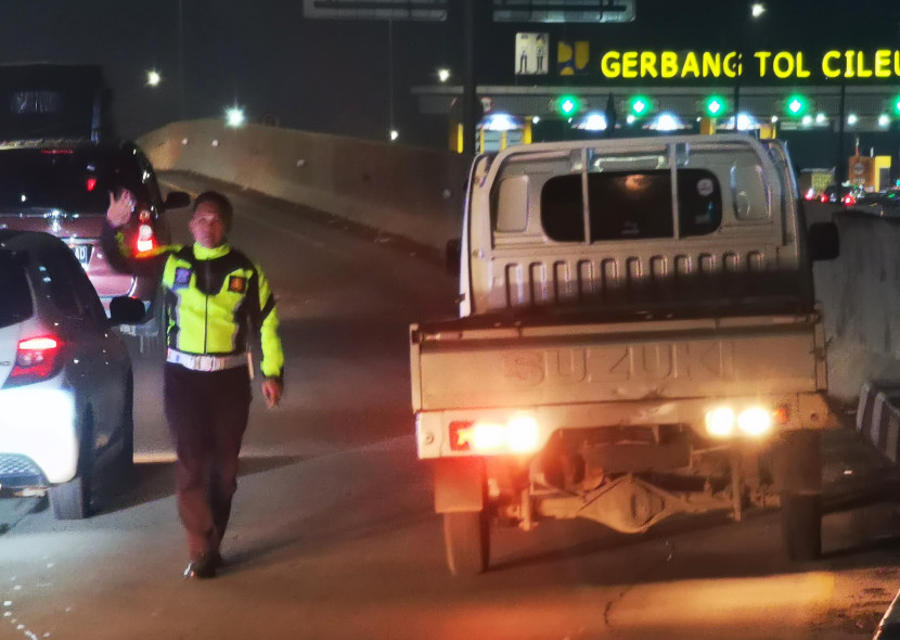 Petugas polisi mengawal proses evakuasi mobil pickup yang terlibat tabrakan beruntun di Ramp jalan tol menuju Gerbang Tol Cileunyi, Jumat (12/4/2024) malam. Foto: Yogi Ardhi/Republika Network