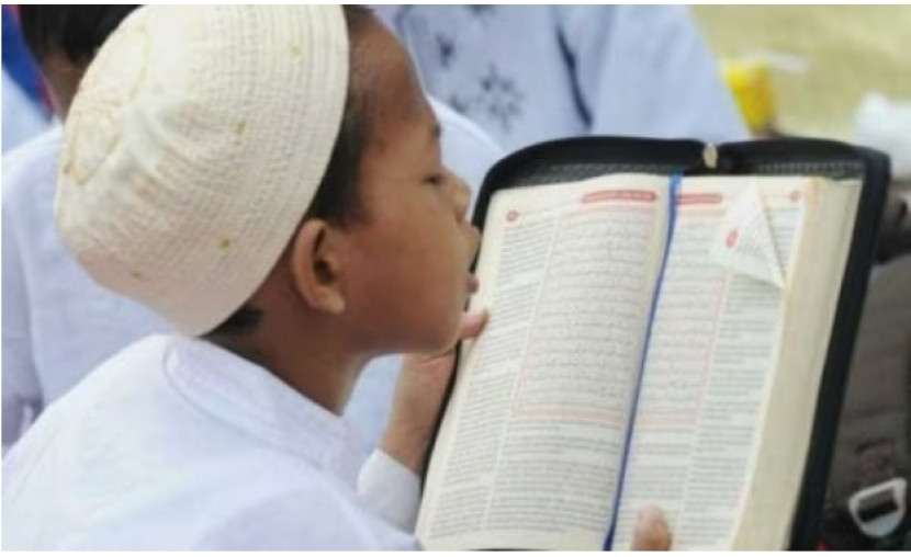  Seorang anak sedang membaca Al-Quran. (Republika)