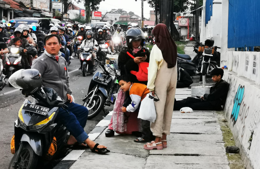 Sejumlah pengendara sepeda motor beristirahat di trotoar jalan di kawasan Bandung Timur.