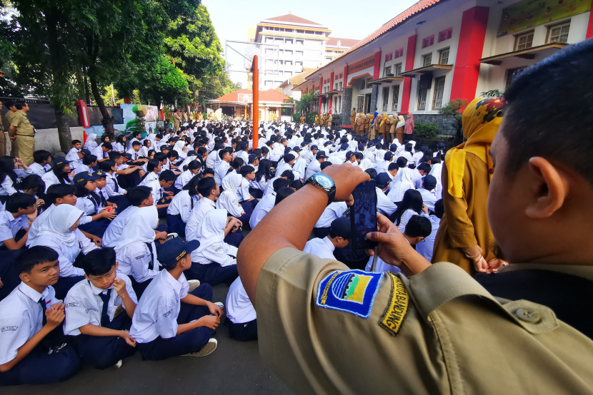 Seorang guru memotret suasana kegiatan halal bihalal di lapang basket SMPN 7 Bandung, Selasa (16/4/2024). (Foto: Yogi Ardhi/Republika Network)