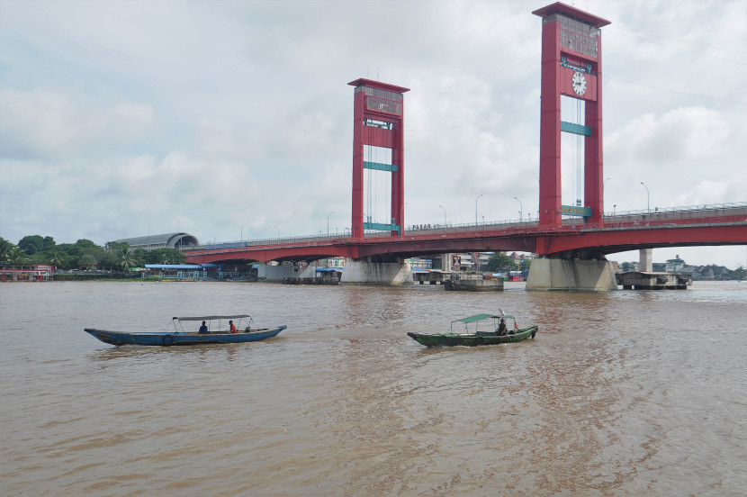 Perahu getek melintasi Sungai Musi di bawah Jembatan Ampera Kota Palembang, Sumatra Selatan, Sabtu (13/4/2024) . (Foto: SumatraLink.id/Mursalin Yasland) 