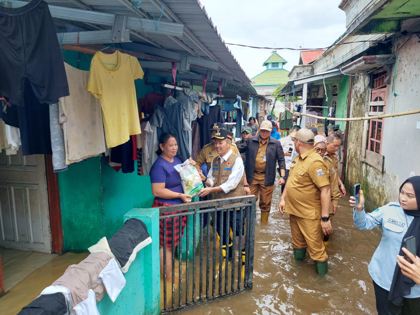 Banjir adalah masalah yang kerap melanda Palembang. Pj Wali Kota Palembang Ratu Dewa memberikan bantuan kepada warga korban banjir. (FOTO: Dinas Kominfo Kota Palembang)