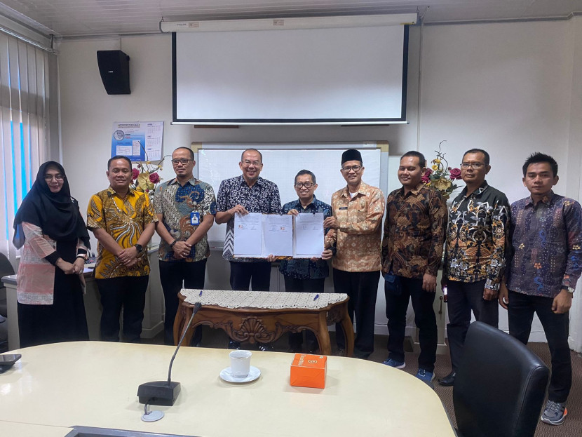 Direktur Tirta Raja, Bertho Darmo Poedjo Asmanto (lima dari kanan) dan Direktur Utama Tirta Musi Andi Wijaya Adani (empat dari kiri) memperlihatkan naskah kerjasama yang ditandatangani. (FOTO: Humas Tirta Raja)