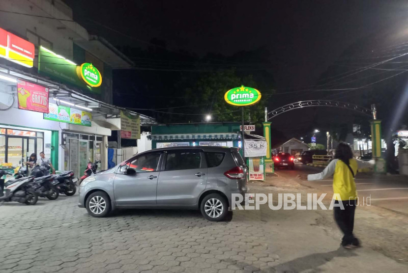 Juru parkir mengatur parkir mobil di minimarket. (FOTO: REPUBLIKA/ Bayu Adji P)