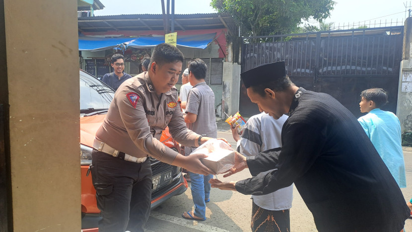 Anggota Polsek Citamiang Polres Sukabumi Kota membagikan nasi kotak ke warga, Jumat (17/5/2024).