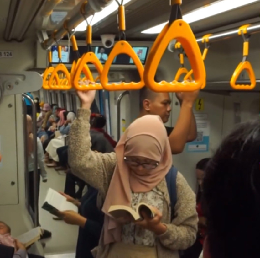 Baca buku di kereta LRT yang melaju. (FOTO: Tangkapan Layar Palembang Book Day)