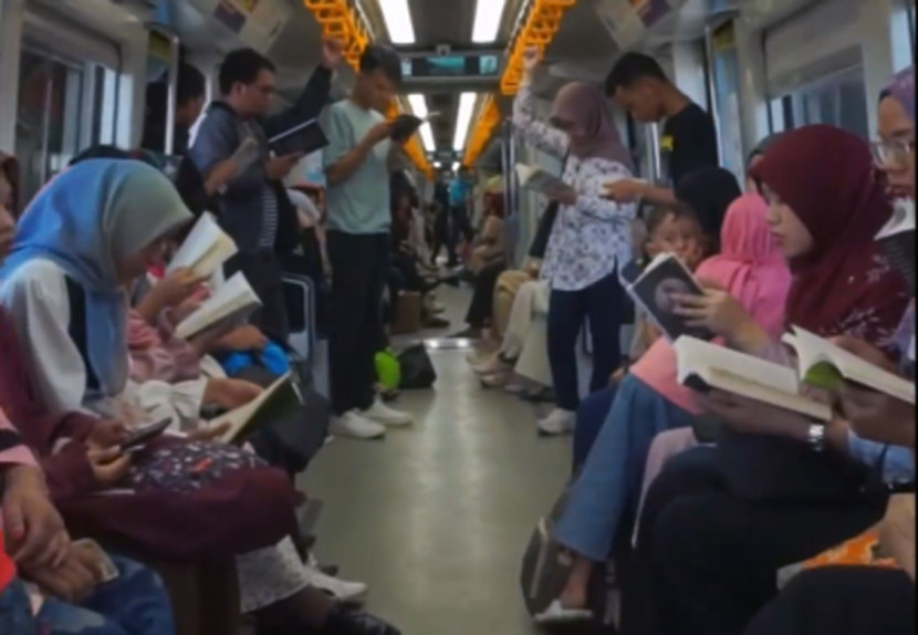 Baca buku di kereta LRT yang melaju. (FOTO: Tangkapan Layar Palembang Book Day)