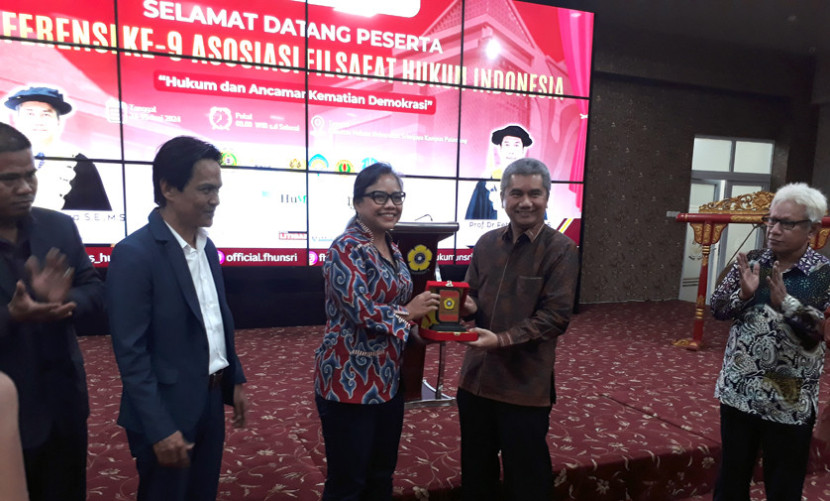 Rektor Unsri Taufiq Marwa memberikan cendera mata kepada keynote speaker Bivitri Susanti pada Konferensi ke-9 Asosiasi Filsafat Hukum Indonesia (AFHI) di kampus Fakultas Hukum Unsri, Senin (24/6). (FOTO: Maspril Aries)