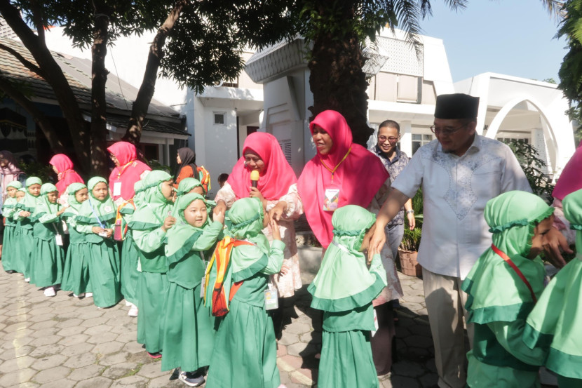 Sejumlah siswa TK Nuurusysyifa' menyalami kepala sekolah dan guru-guru mereka.