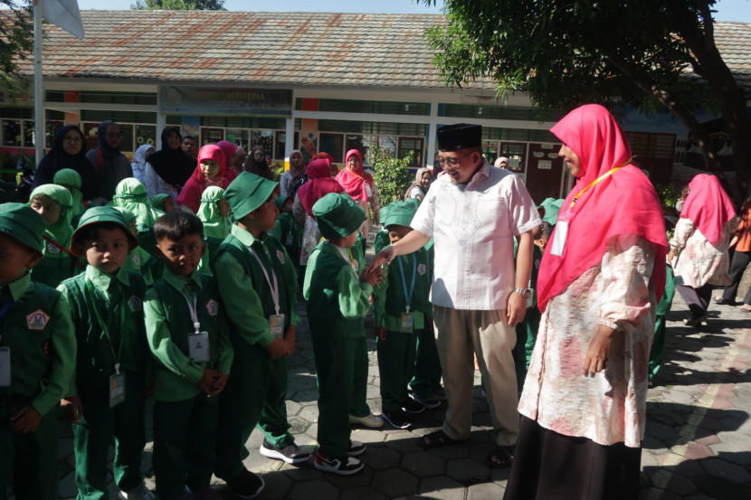 Sejumlah guru dan kepala sekolah TK Nuurusysyifa' menyambut kehadiran siswa.